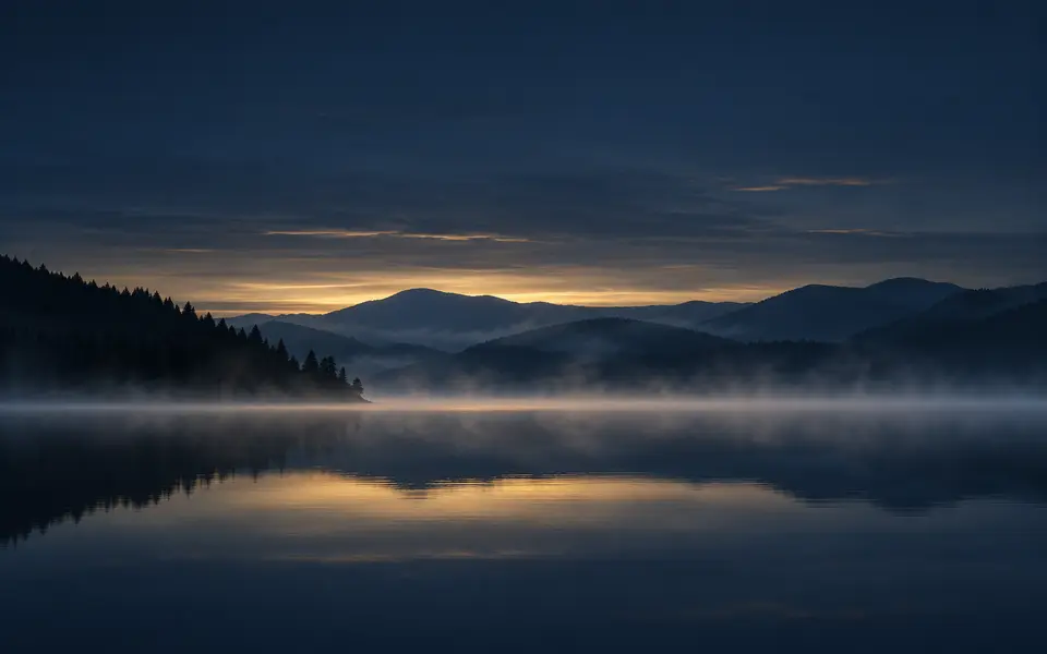 Lago immobile nella luce quieta prima dell’alba