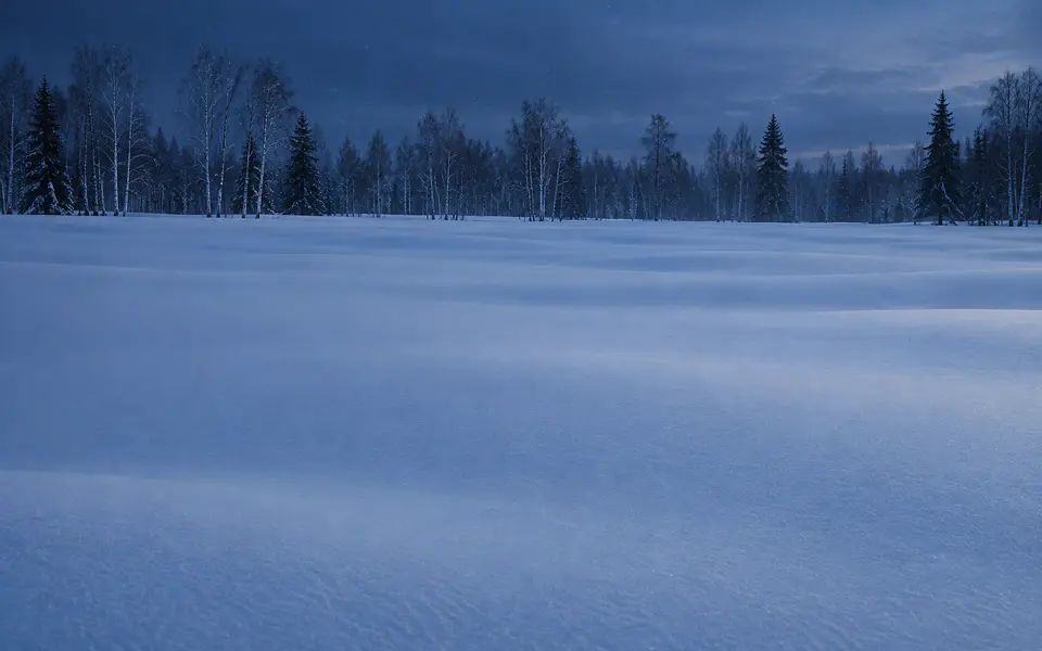Distesa di neve intatta nella luce blu del crepuscolo