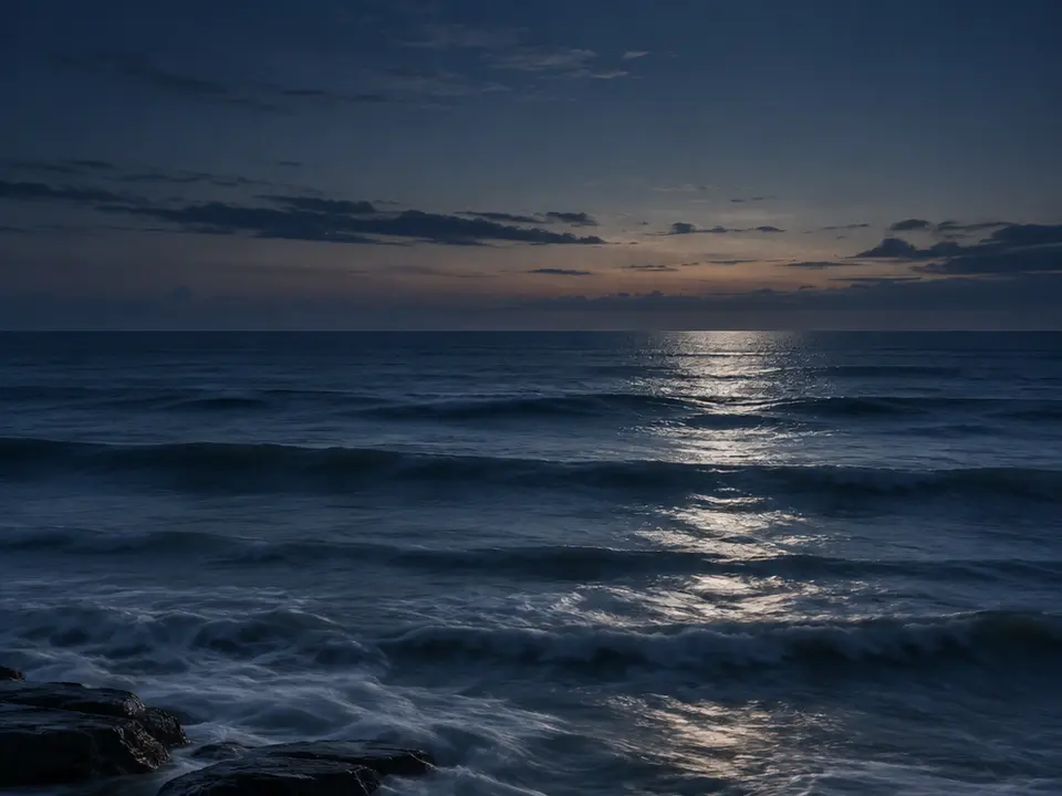 Oceano notturno attraversato da un riflesso argenteo